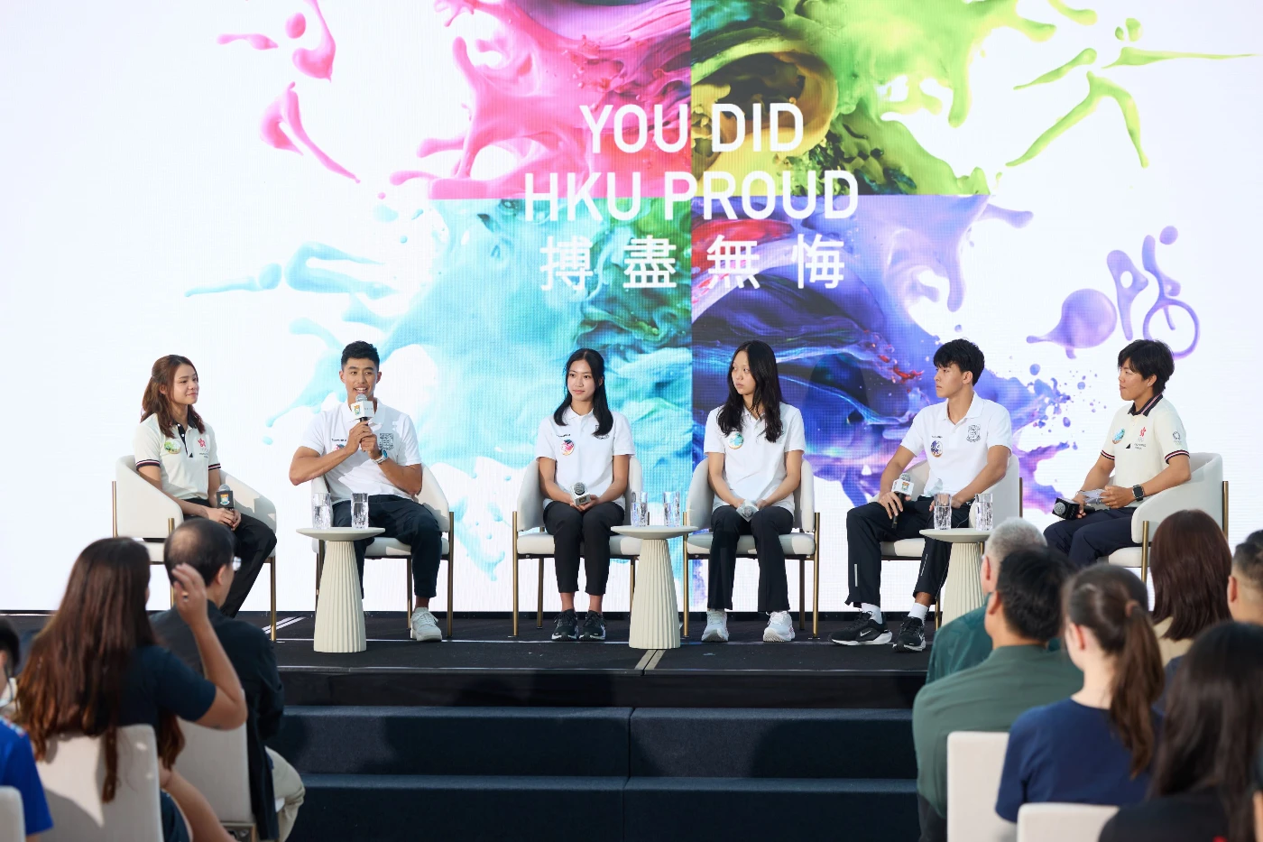 Lee Shau Kee Top Athletes Scholars Rafeek Kikabhoy (2nd  left); Pak Hoi Man Chloe (3rd  left); Cheung Sum Yuet Cindy (3rd right); and Magnus Prostur Johannsson (2nd right) share their personal experience as athletes with the hosts, fencer Coco Lin (left), and windsurfer Hayley Chan (right) on stage.