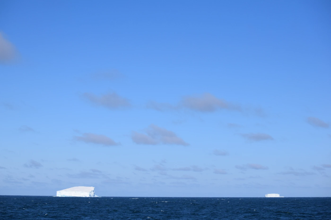 Beneath the vast blue sky, the icebergs of the Southern Ocean stand silently, witnessing one of Earth's most untouched and fragile beauties. Photo credit: Minoru Ikehara.