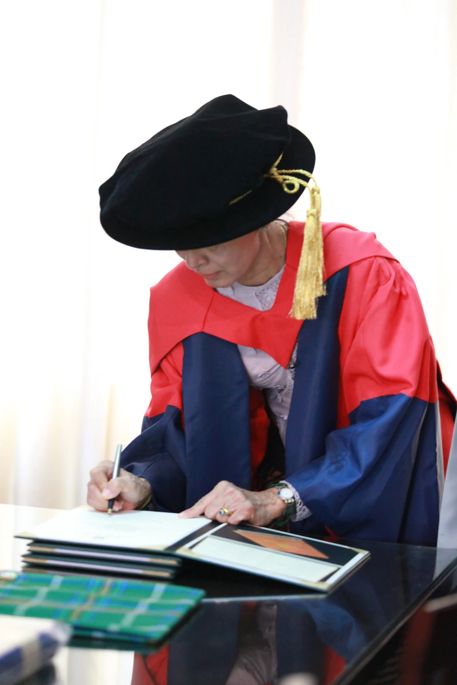 Daw Aung San Suu Kyi signs on the University Register of Honorary Graduates.