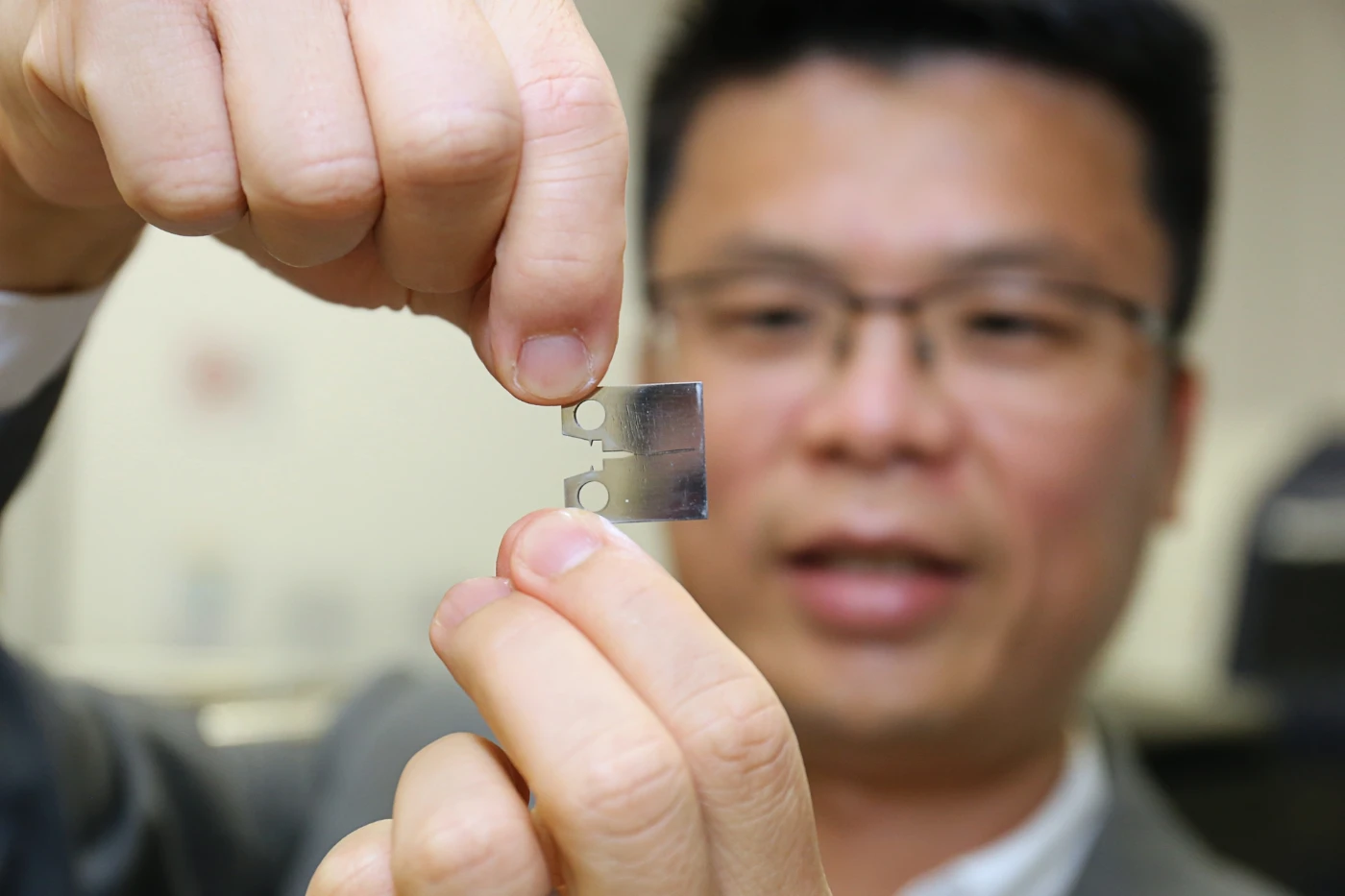 Professor Huang Mingxin shows a thin light piece of super steel which demonstrates a ultra high level of fracture resistance, strength and ductility.