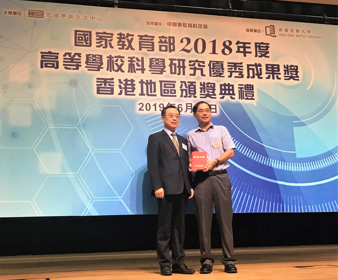 （左起）中聯辦教育科技部副巡視員劉志明先生與與獲得2018年度教育部自然科學獎一等獎的趙國春教授