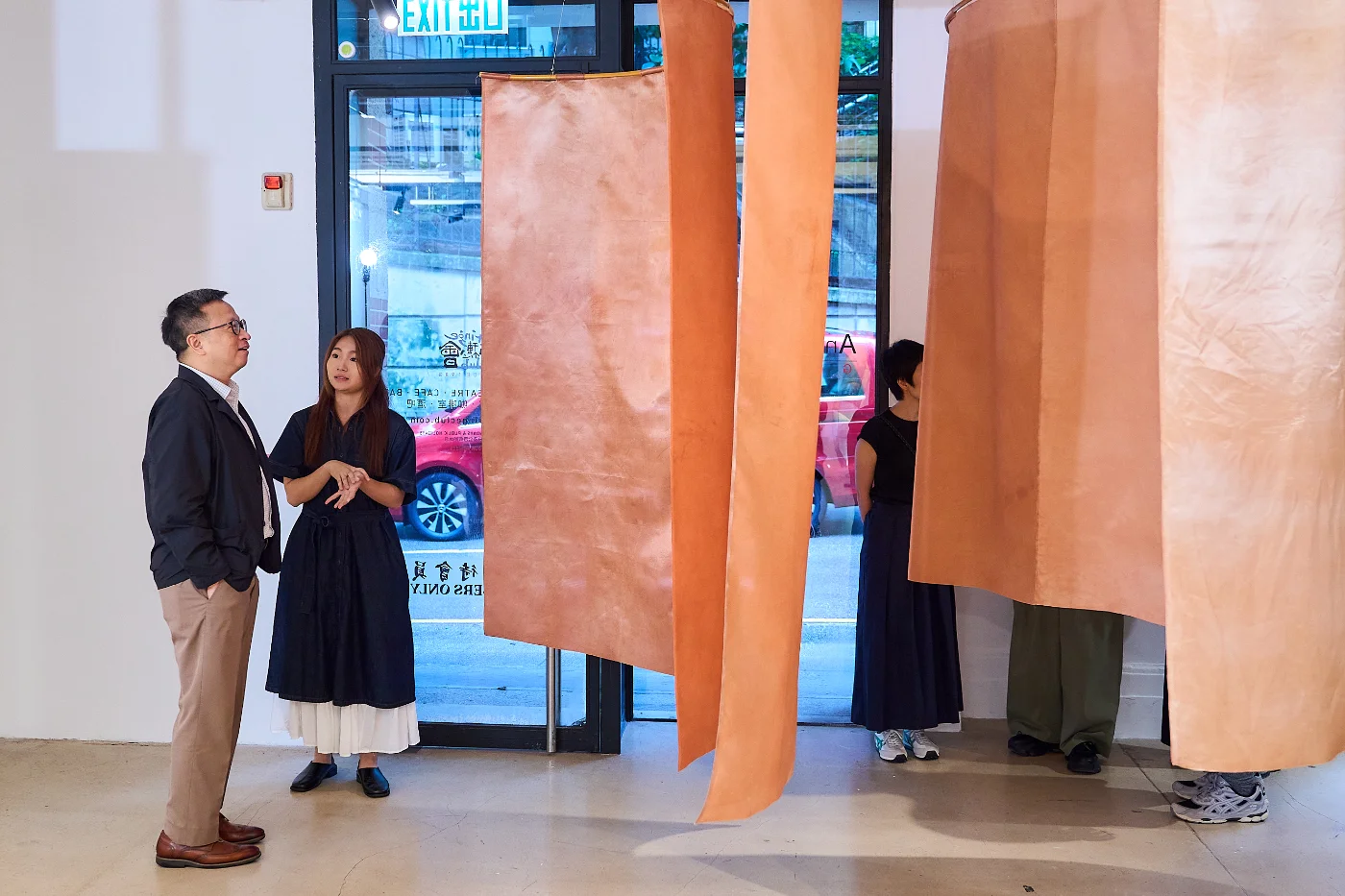An exhibiting artist introduces their work to guests.